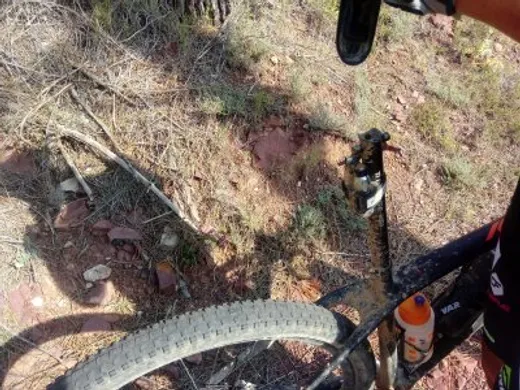 Una MTB apoyada en el monte con la tija partida