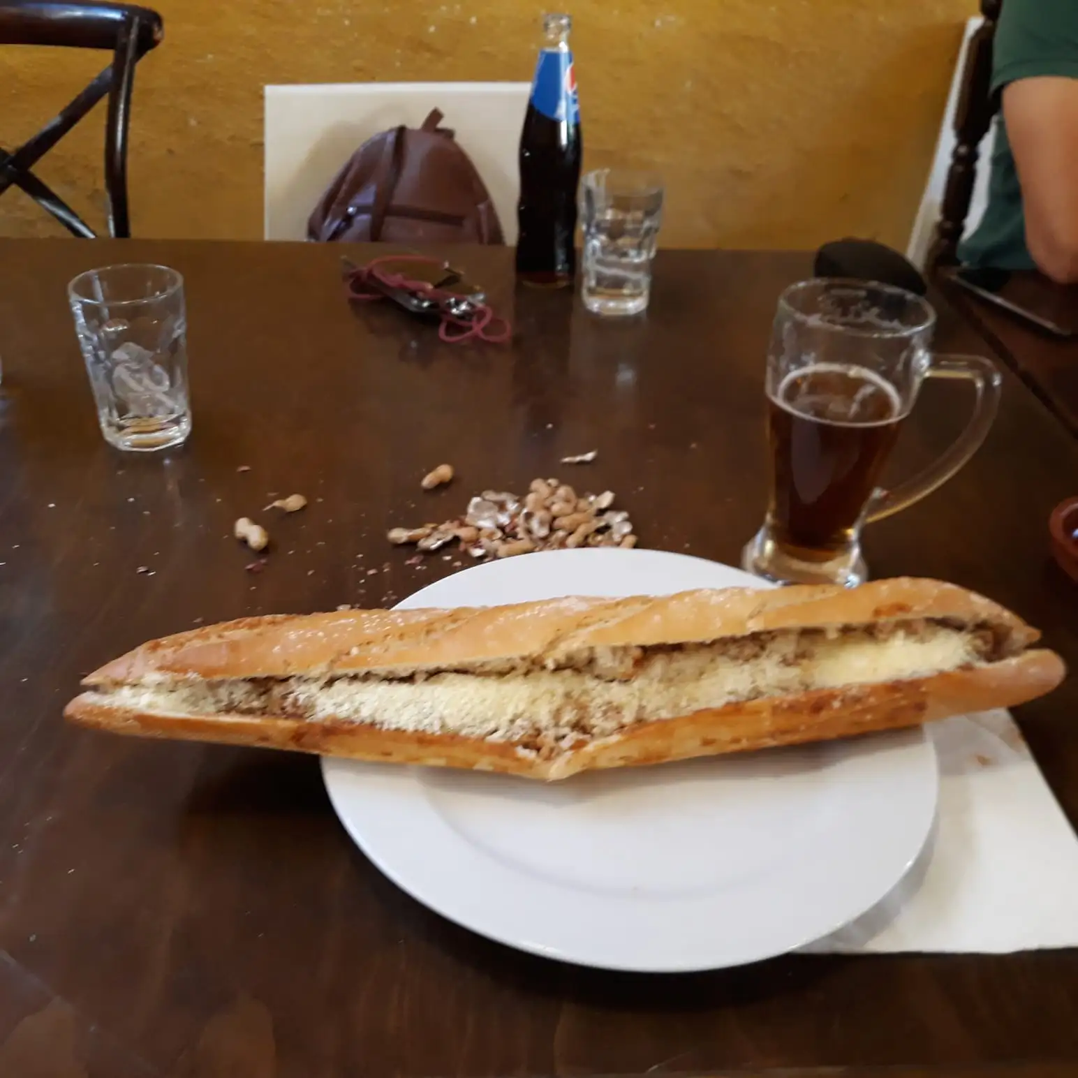 Un bocata enorme con cerveza en la mesa del bar