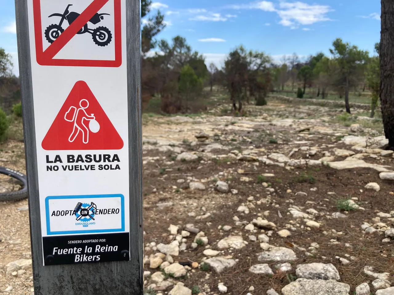 La placa del sendero vista tras la rueda de una MTB