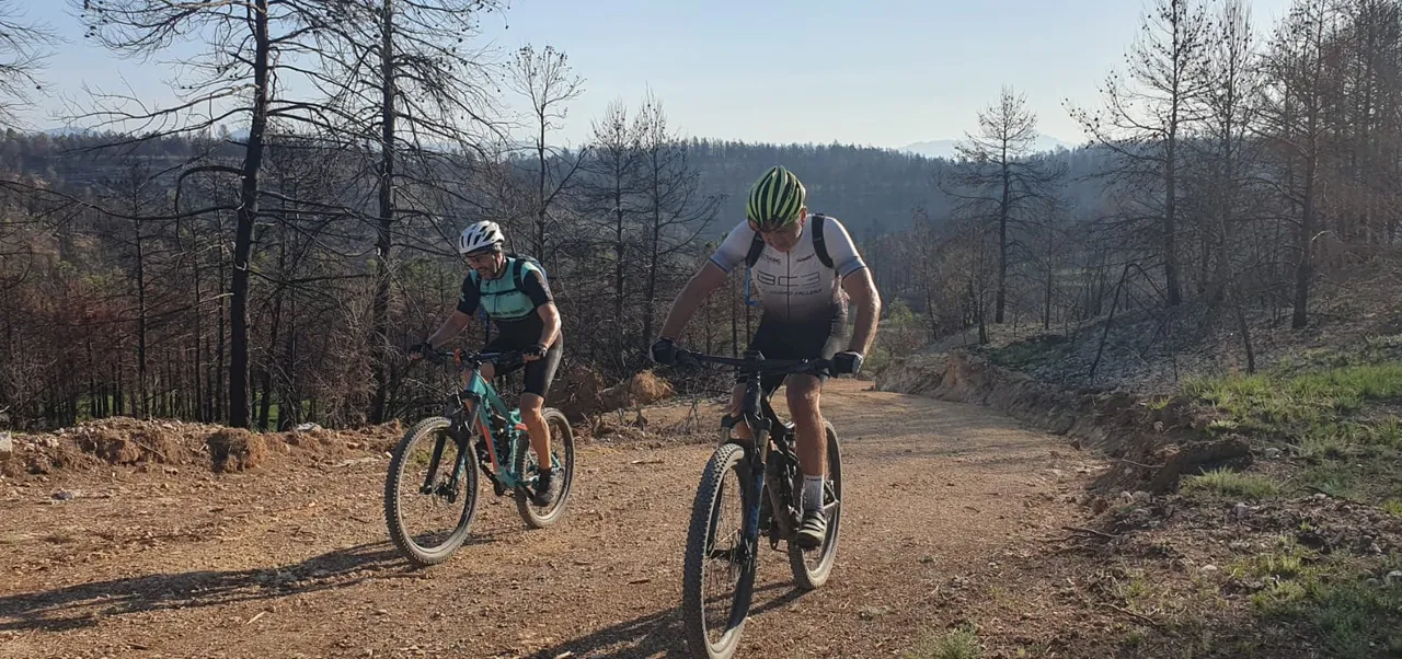 Dos bikers por la pista con la sierra calcinada de fondo