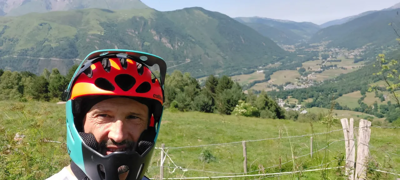 Primer plano de casco integral con el valle pirenaico detrás