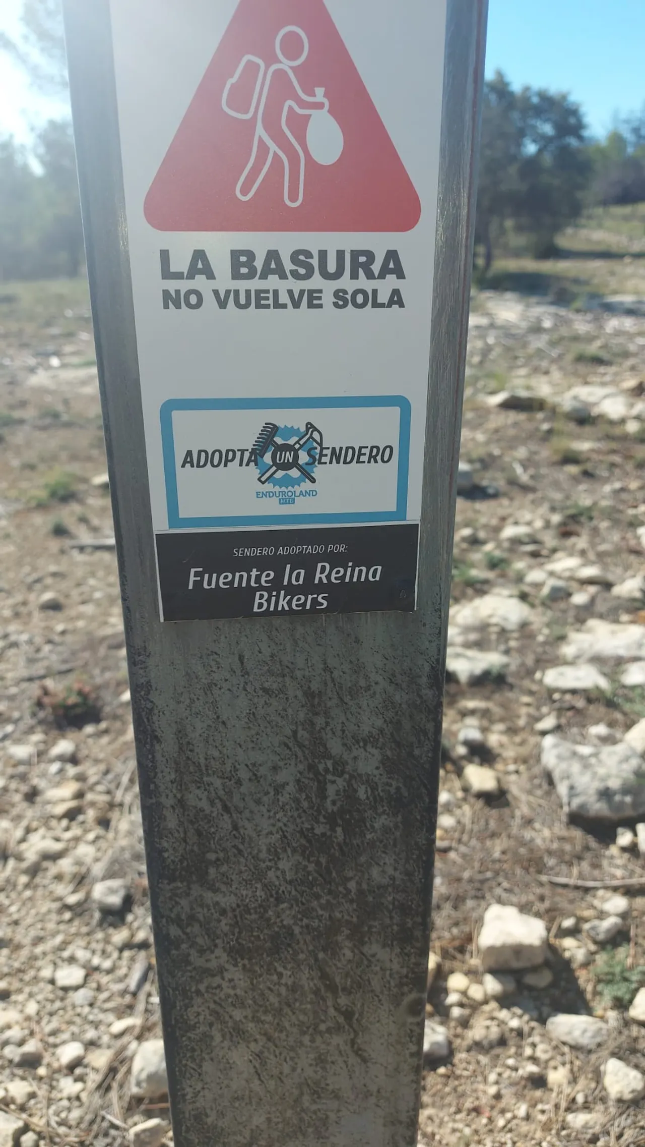 El poste del sendero con la placa 'Sendero adoptado por Fuente la Reina Bikers'