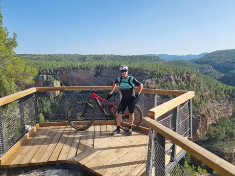 Un zorrico con su e-MTB en el mirador de madera sobre las Hoces
