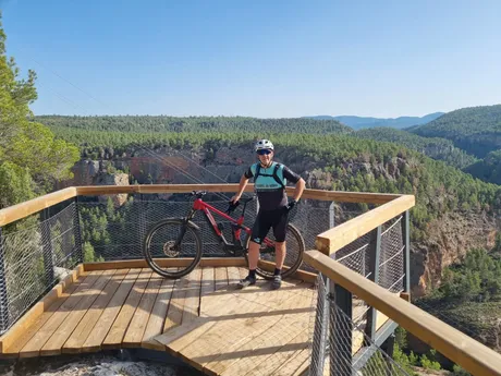 Un zorrico con su e-MTB en el mirador de madera sobre las Hoces